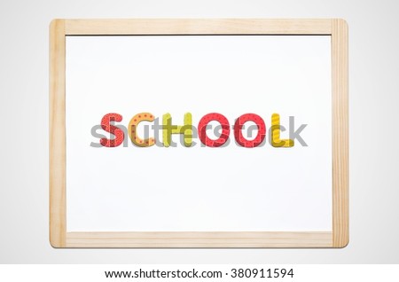 Hand put the word School on magnetic board. Colorful alphabet kit
