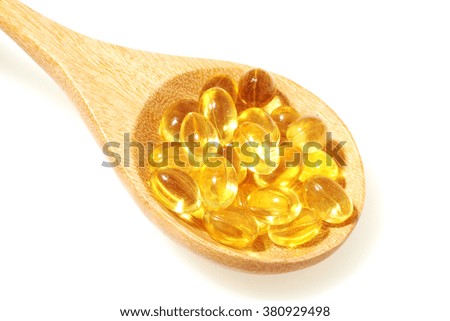 Fish oil capsules in a spoon isolated on white background