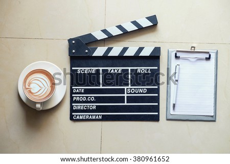 Movie clapper notepad and coffee of cup on office table.vintage effect
