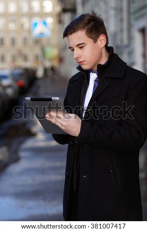 Classic dressed young man with a tablet pc.
