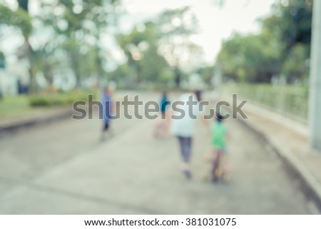 vintage tone blur image of people biking on street with open space to the green garden for background usage .