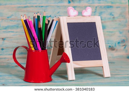 color pencil in red watering can and small 
Blackboard