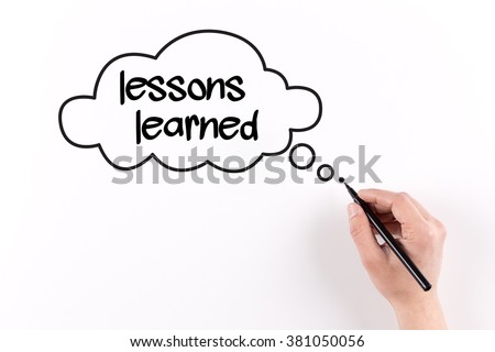Hand writing Lessons learned on white paper, View from above Royalty-Free Stock Photo #381050056