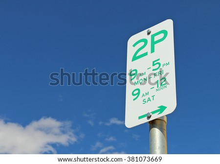 green and white Two Hour Parking sign in a blue sky