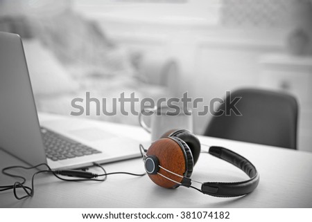 Headphones and laptop on white table against defocused background