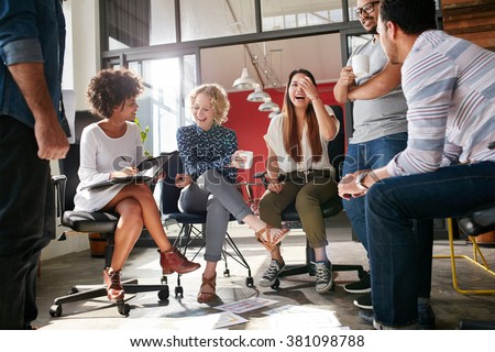 Shot of a group of young business professionals having a meeting. Diverse group of young designers smiling during a meeting at the office. Royalty-Free Stock Photo #381098788