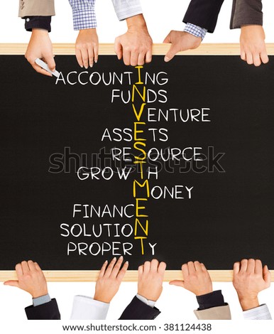 Photo of business hands holding blackboard and writing INVESTMENT concept