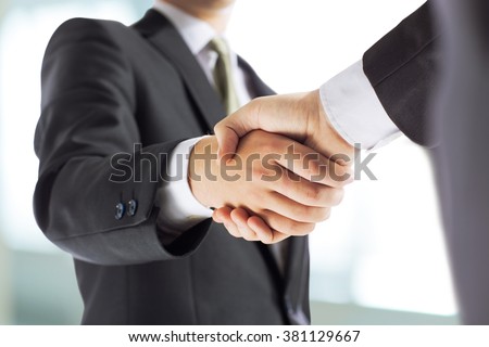 business and office concept - businessman shaking hands each oth Royalty-Free Stock Photo #381129667