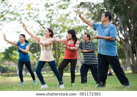 Elderly Asian people practicing Tai Chi together Royalty-Free Stock Photo #381172381