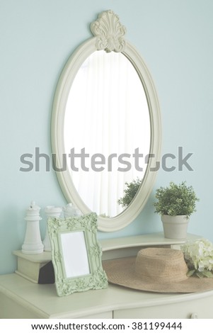 High key bright photograph of vintage picture frame on dressing table in bedroom