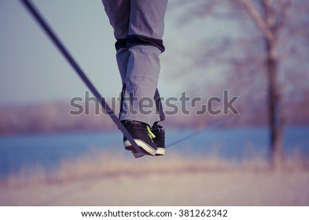 Man walking on slackline with river view in the park