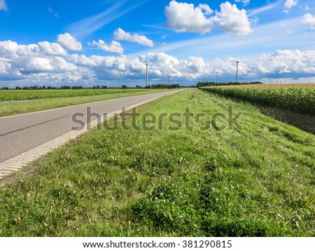 Country road, farmland and wind turbines in Flevoland polder, the Netherlands