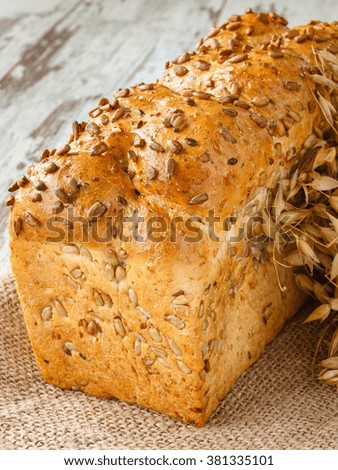 Fresh bread with sunflower seeds and wheat on the wooden boards in rustic style