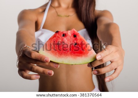 Details of the hands of a young woman with a slice of watermelon 