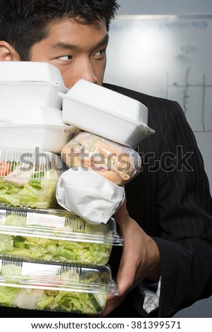 Businessman holding lots of food