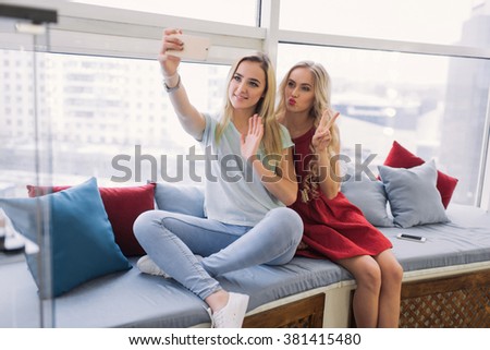 Two beautiful and young girlfriends taking pictures