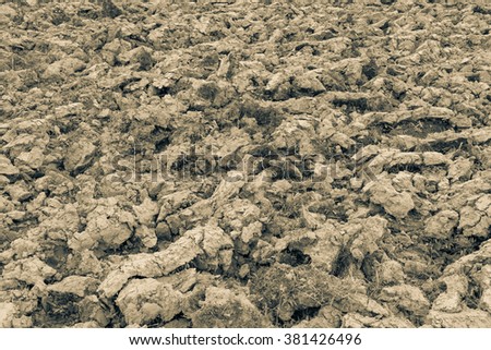 Ploughed soil field at the farmland. Natural brown dirty texture of organic and plowed rural land ground. Prolific rough surface for outside planting in the countryside.Agricultural texture background
