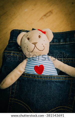 Teddy bear on jeans background. The picture concept is about of love. Vintage retouching.