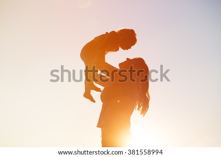 mother and little daughter play at sunset