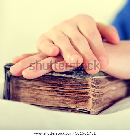 Toned Photo of Hand on the Old Book in the Bed closeup