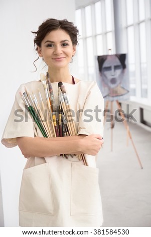 Girl painter with her paint holding brushes