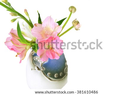 Close-up of colorful spring flowers mix in small vase isolated on the white background.
