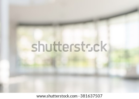 Blur office building, healthcare clinic, hospital or school background interior view looking out toward to empty lobby and entrance doors and glass curtain wall  Royalty-Free Stock Photo #381637507