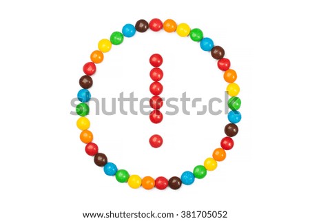 Exclamation mark in a circle of colored candies isolated on white background. Sign of attention, warning of the danger.