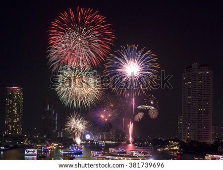 Firework over city at night with reflection in water