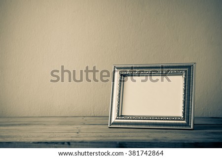 Still life style of Vintage photo frame on wooden table over grunge background
