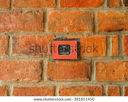 Red fire alarm on an old brick wall        