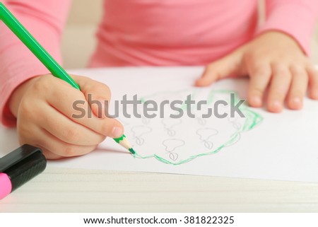 Child drawing tree with pencils on paper, closeup