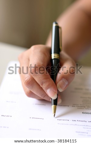signing an important document with a black pen