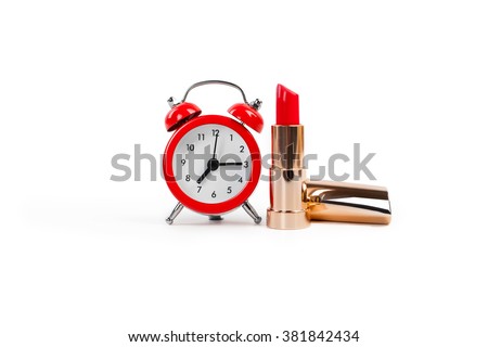 Red lipstick and alarm clock on a white background Royalty-Free Stock Photo #381842434