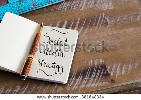 Retro effect and toned image of notebook next to a fountain pen. Business concept image with handwritten text SOCIAL MEDIA STRATEGY , copy space available