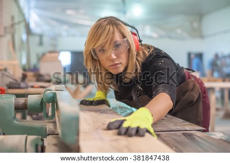 Female carpenter Using Electric Sander for wood Royalty-Free Stock Photo #381847438