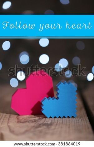 Hearts on wooden table and blurred background with lights