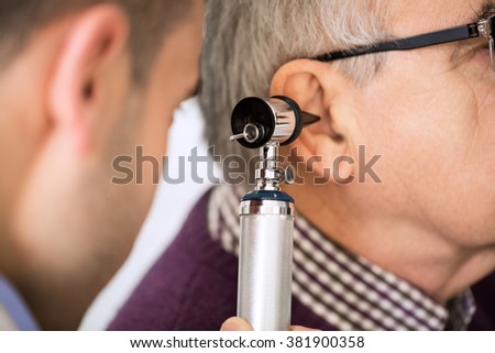 Doctor Examining old Patient's Ear Royalty-Free Stock Photo #381900358