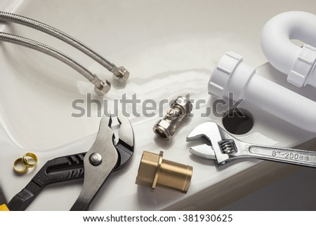 Various plumbing parts on a bathroom basin Royalty-Free Stock Photo #381930625