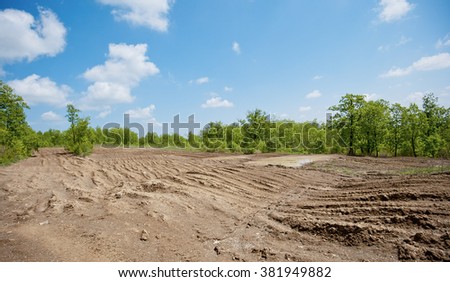 dirty broken rural road with deep tire tracks Royalty-Free Stock Photo #381949882