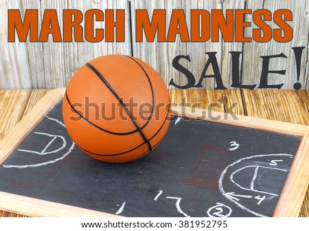 An orange basketball on a wood floor in front of a wood wall with set plans is a great image for basketball season, March Madness,or championship playoffs. Set plans are  on blackboard. Text added.