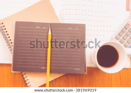 note book and planner on the wooden table with vintage color concept