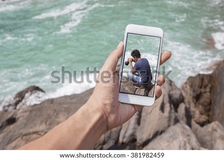 hand holding smartphone against nature .sea background Ecology concept. World Environment Day concept