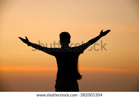 Silhouette of man on top of mountain at sunset