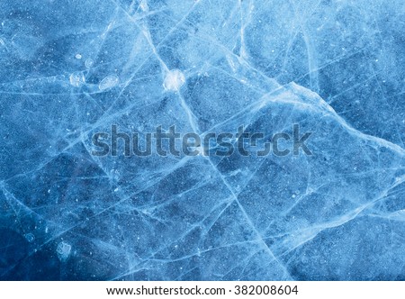 A network of cracks on a piece of blue ice with air bubble. Royalty-Free Stock Photo #382008604