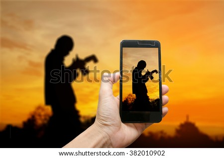 capture camera smartphone,silhouette beautiful women with photography pre wedding outdoor the sunset