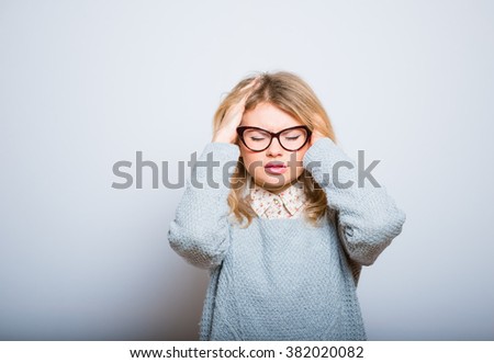 blonde girl has a headache or pressure in glasses isolated on a gray background