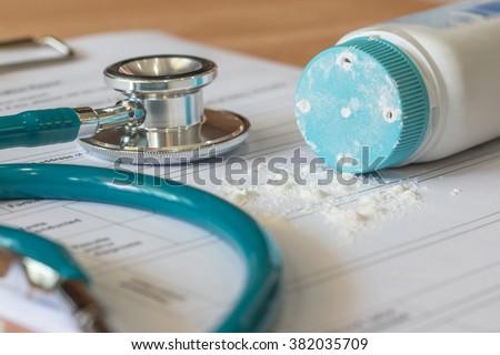 Baby powder product with talc mineral spilling over diagnosis record paper on doctor's pad with stethoscope in teal color background Royalty-Free Stock Photo #382035709