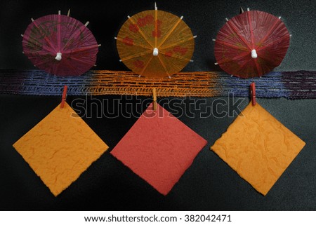 Party concept - colorful paper umbrellas, paper notes and clothespins, copy space
