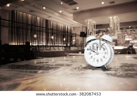 retro alarm clock in restaurant, blur vintage background